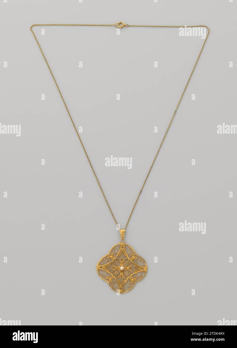 Filigrein Anhänger in Gold mit einer natürlichen Perle der Halskette, um 1900 Filigrein Anhänger in Gold mit einer natürlichen Perle an Halskette. Die Pendelleuchte hat die Form eines Vierdurchgangs mit einem konkaven Fenster, in dem die Perle mittig platziert ist und ein Plattenauge hat. Der Anhänger wurde für eine Dame aus einer niederländischen Familie gefertigt, die eine Plantage in Niederländisch-Indien besaß. Die Halskette ist ein Anker collier mit einem Federring als Verschluss. Niederländisch-Indien, das Gold (Metall). Filigraner Filigrein-Anhänger in Gold mit einer natürlichen Perle an der Halskette. Die Pendelleuchte hat die Form eines Viergangs mit einem konkaven Fenster in W Stockfoto