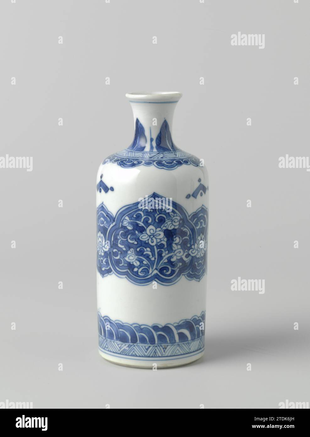 Kannige Flaschenvase mit Blumenrollen in Reserve in ruyi-förmigen Tafeln, anonym, ca. 1680 - ca. 1720 Flaschenförmige Vase aus Porzellan mit zylindrischem Korpus und kurzem, spreizendem Hals, blau lackiert. Auf dem Bauch ein breites Band mit verbundenen Ruyi-förmigen Kartuschen mit Blumenreben vor blauem Hintergrund. Über dem Fuß ein Band mit Zickzackmuster und stilisierten Blattmotiven. Auf der Schulter ein Band mit Zickzackmuster und hängenden Ruyi-Motiven. Am Hals spitz zulaufende Blattmotive. Blau Weiß. Porzellan. Glasur. Kobalt-(Mineral-)Malerei/Glasur Flasche -Shap Stockfoto