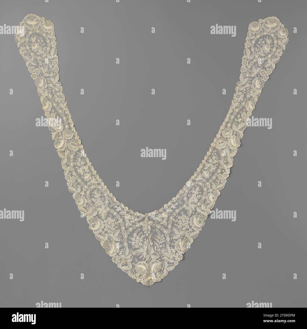 Schalkragen der Nadelseite mit Schalterkette, anonym, ca. 1870 - ca. 1880 Ein spitz geweitetes Rückenstück verbindet zwei lange, schmale Slips mit geweiteten Enden. Fünf Mal wurde ein Pendelband aus verbundenen Rädern in eine Schleife gelegt, in der jeweils ein Rosenzweig verzweigt ist. Die Röschen zeigen das Relief von sichelförmigen Blütenblättern. Der Blumenstrauß im hinteren Teil besteht aus drei hängenden Rosenzweigen. Die drei oder fünfzig Blätter werden alle durch das mittlere Bedürfnis in eine dicht geschlossene und eine offene Hälfte mit Sprenkeln geteilt. Richten Sie den Blick auf Bruxelles. Brüsseler Leinen (Material) Ein spitz breiter Rücken Stockfoto