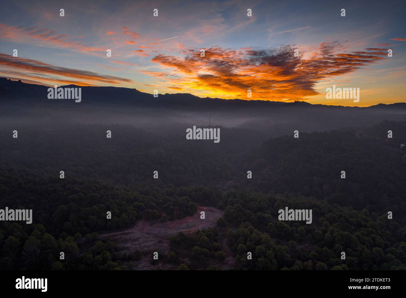 Sonnenaufgang im Naturpark Sant Llorenc del Munt i l'Obac mit rotem Himmel und Nebel. Luftaufnahme (Vallès Occidental, Barcelona, Katalonien, Spanien) Stockfoto