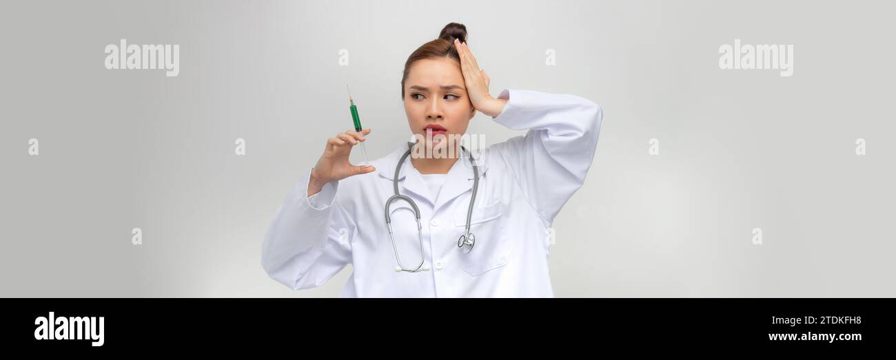 Junge Frau, die die Spritze hält, gestresst und frustriert mit Hand an Kopf, überrascht und wütend im Gesicht Stockfoto