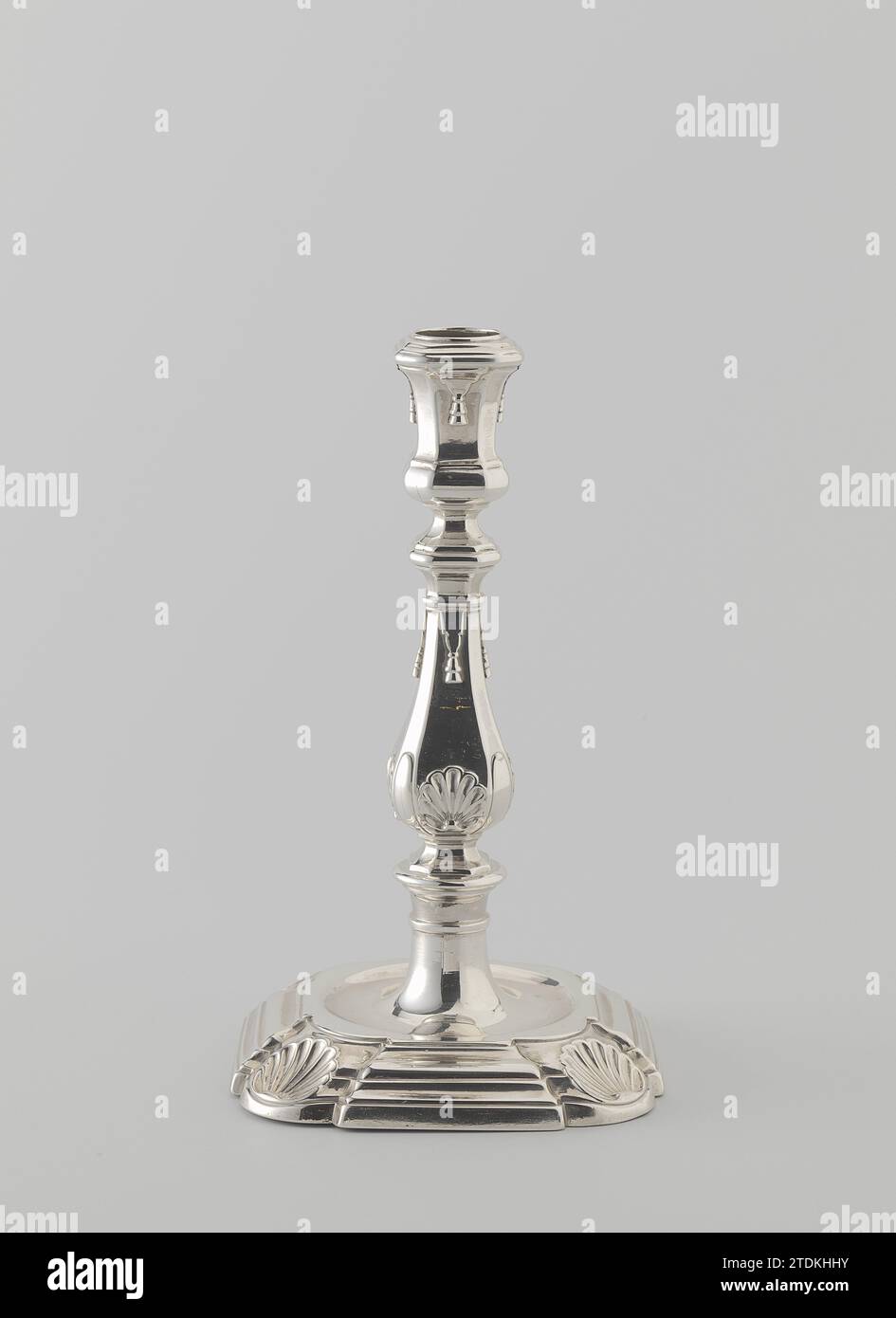Kerzenhalter auf quadratischem Sockel mit eingekerbten, runden Ecken, die mit Muscheln verziert sind, Pieter de Keen (zugeschrieben), Kerzenhalter aus Silber 1729. Der quadratische, profilierte, verjüngende Fuß ist eingedrungen, runde Ecken, die mit einer Schale verziert sind. In der flachen Oberseite befindet sich ein runder Boden, aus dem der ebenfalls runde, leicht angerührte, durch einen Ring aus dem Fuß des Fußes steigt. Dieser trägt eine flache Scheibe, auf der der balusterförmige Stamm aufliegt. Sowohl der Stamm als auch der vasenförmige Kerzenhalter sind quadratisch mit abgeschrägten Ecken; beide sind reich profiliert. Die vier Seiten des Kofferraums sind im verziert Stockfoto Kerzenhalter auf quadratischem Sockel mit eingekerbten, runden Ecken, die mit Muscheln verziert sind, Pieter de Keen (zugeschrieben), Kerzenhalter aus Silber 1729. Der quadratische, profilierte, verjüngende Fuß ist eingedrungen, runde Ecken, die mit einer Schale verziert sind. In der flachen Oberseite befindet sich ein runder Boden, aus dem der ebenfalls runde, leicht angerührte, durch einen Ring aus dem Fuß des Fußes steigt. Dieser trägt eine flache Scheibe, auf der der balusterförmige Stamm aufliegt. Sowohl der Stamm als auch der vasenförmige Kerzenhalter sind quadratisch mit abgeschrägten Ecken; beide sind reich profiliert. Die vier Seiten des Kofferraums sind im verziert Stockfoto