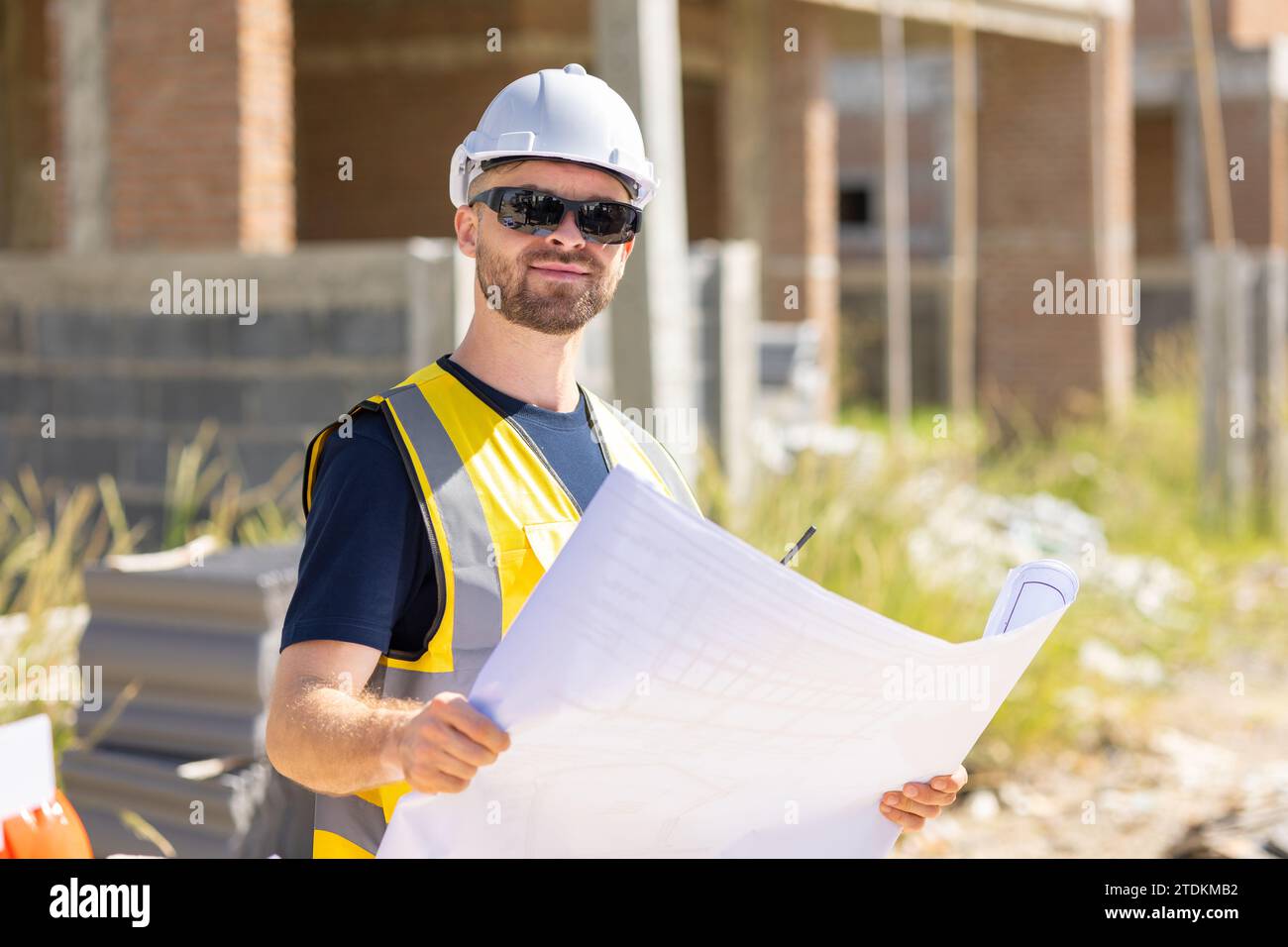 Professioneller Bauarbeiter Ingenieur männlich. Bauunternehmer für Immobilienhäuser. Intelligenter Architekt, der auf der Baustelle arbeitet. Stockfoto