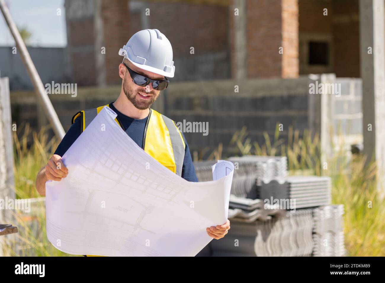 Professioneller Bauarbeiter Ingenieur männlich. Bauunternehmer für Immobilienhäuser. Intelligenter Architekt, der auf der Baustelle arbeitet. Stockfoto
