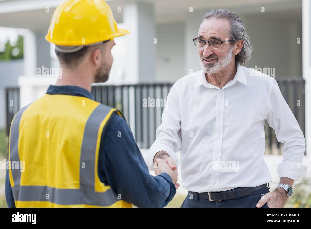 Geschäftsmann Projektleiter oder Immobilienunternehmer Grundstücksanleger Happy Hand schütteln mit Ingenieur Meister Baumeister auf der Hausbaustelle. Stockfoto