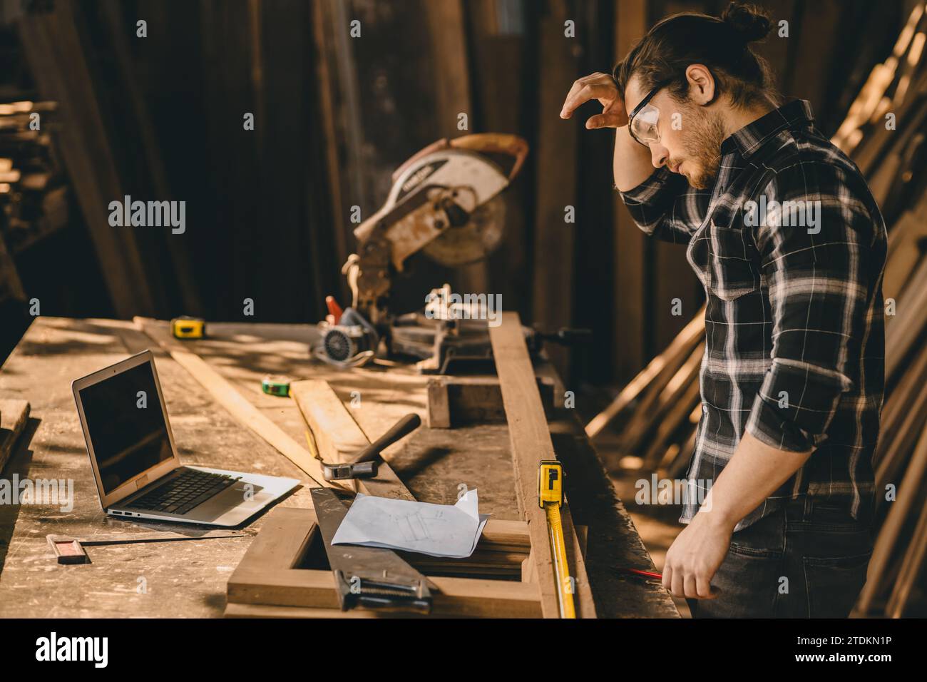 Müder Zimmermann, männlich, hart gearbeitet. Das Personal in der Holzmöbelwerkstatt war müde und staubig Stockfoto