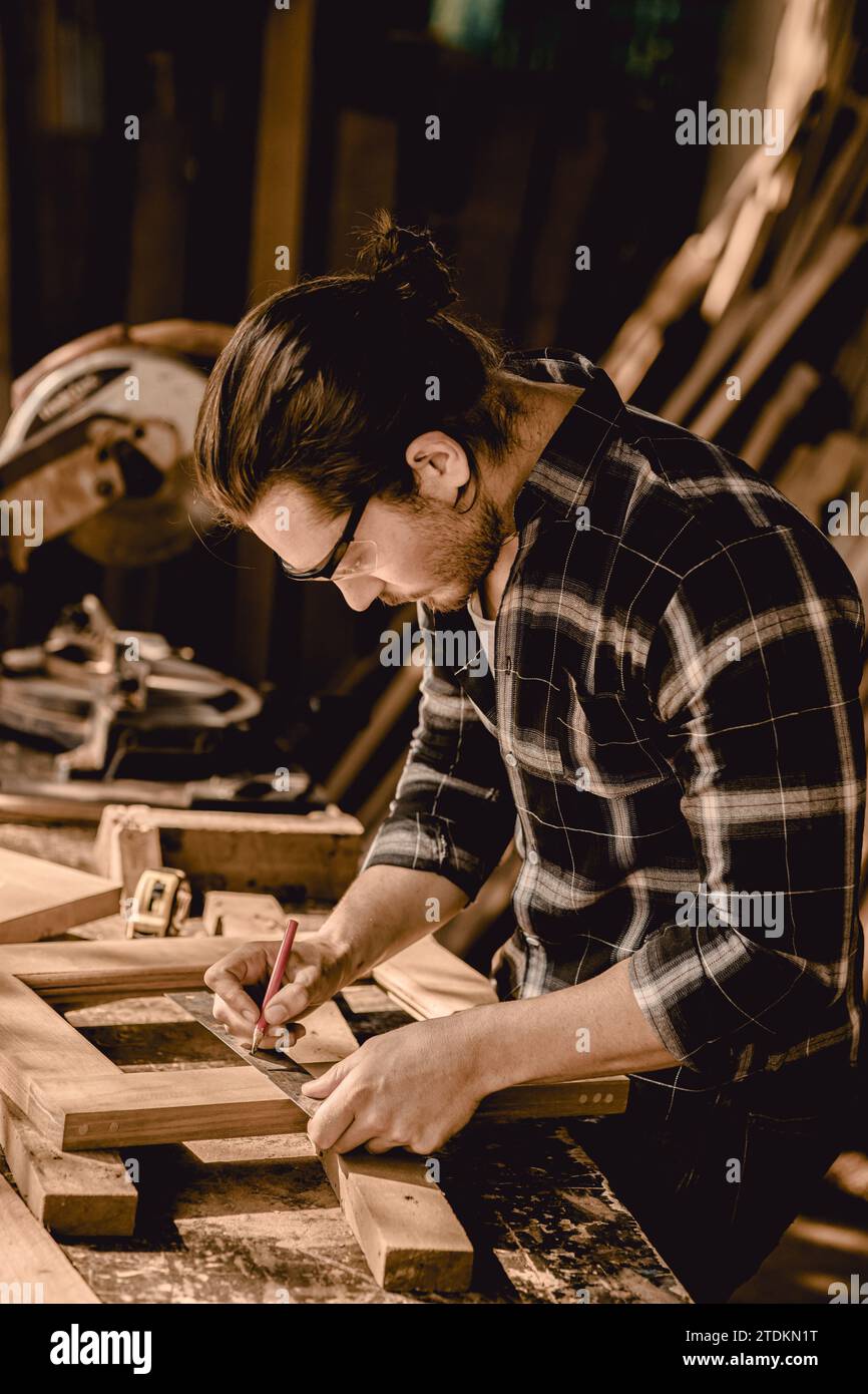 Zimmermann handwerklich Herstellung von Holzmöbeln in Holzwerkstatt professionelles Aussehen hohe Fähigkeiten echte authentische handgefertigte Arbeiter vertikale Aufnahme. Stockfoto