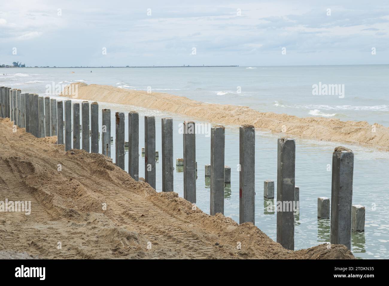 Breakwater Seawall Wellenschlagbarriere im Bereich der Seeufersandbucht wird derzeit Betonsäulen installiert Stockfoto