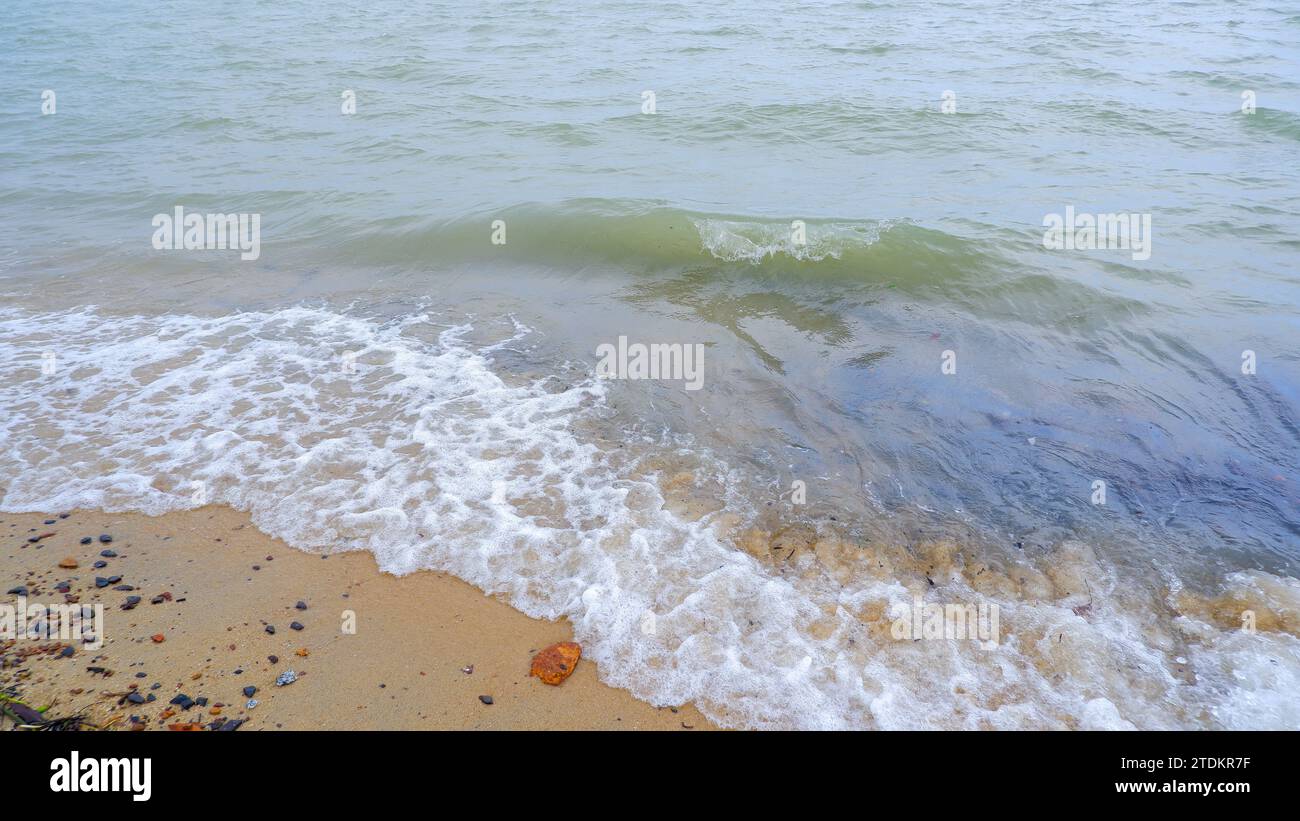 Close-up View, natürliche Sicht auf die brechenden und schäumenden Meereswellen, an der Küste von Tanjung Kalian, Indonesien Stockfoto