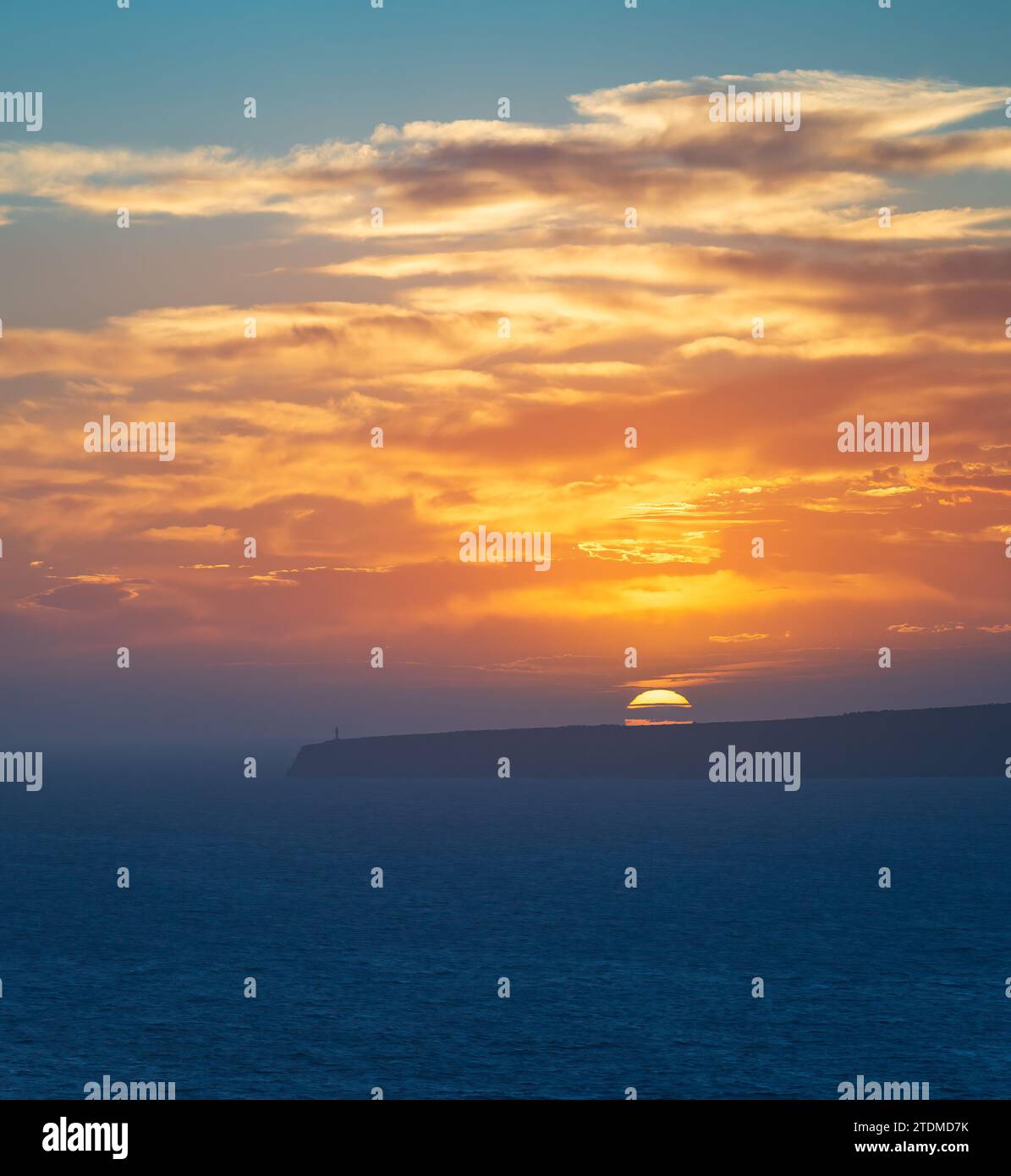 Majestätischer Sonnenuntergang über Klippen und Leuchtturm am Unendlichen Meer Stockfoto