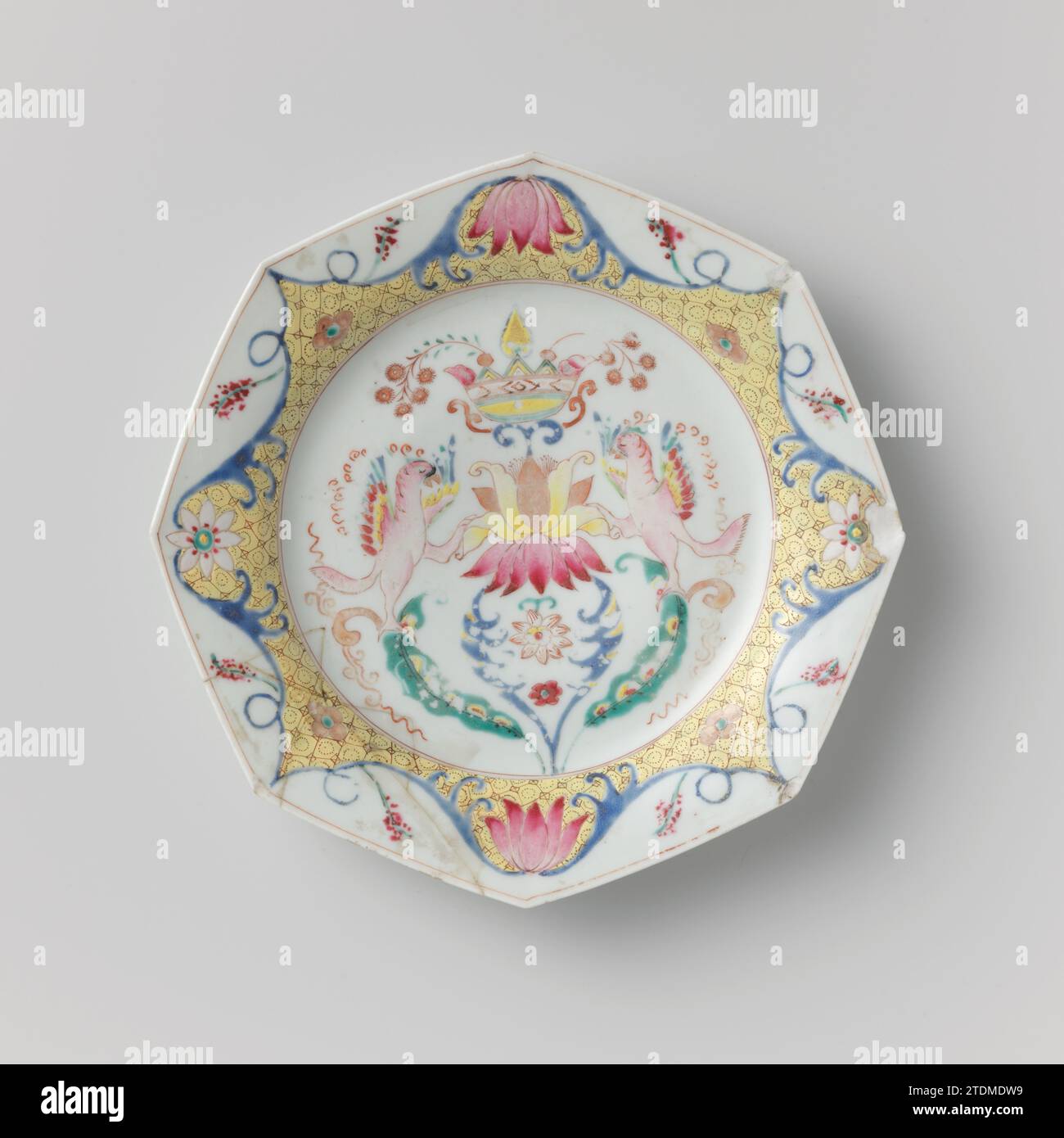 Achteckige Platte mit einem gekrönten Lotus mit Vögeln und Blumenrollen, anonym, ca. 1800 - ca. 1899 achteckige Porzellanplatte, auf der Glasur in blau, rot, rosa, grün, gelb gemalt, schwarz und Gold. Auf der Wohnung ein gekrönter Lotus mit einem Vogel auf beiden Seiten (Papagei?) Und Blumenreben; der Rand mit einem komplizierten Zierband mit Servierwerk und stilisierten Blumen; der Rücken mit drei Zweigen. Platte ist gebrochen; einige Absplitterungen in der Kante. Famle Rose. Porzellan. Glasur. Gold (Metall) Malerei / Vergoldung / Glasur achteckige Platte aus Porzellan, auf der Glasur in blau, rot, rosa, grau gemalt Stockfoto