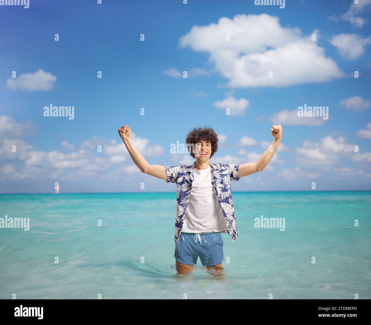 Ein überfröhlicher junger Mann in einem Sommerurlaub, der Glück mit den Armen im Meer gestreift hat Stockfoto
