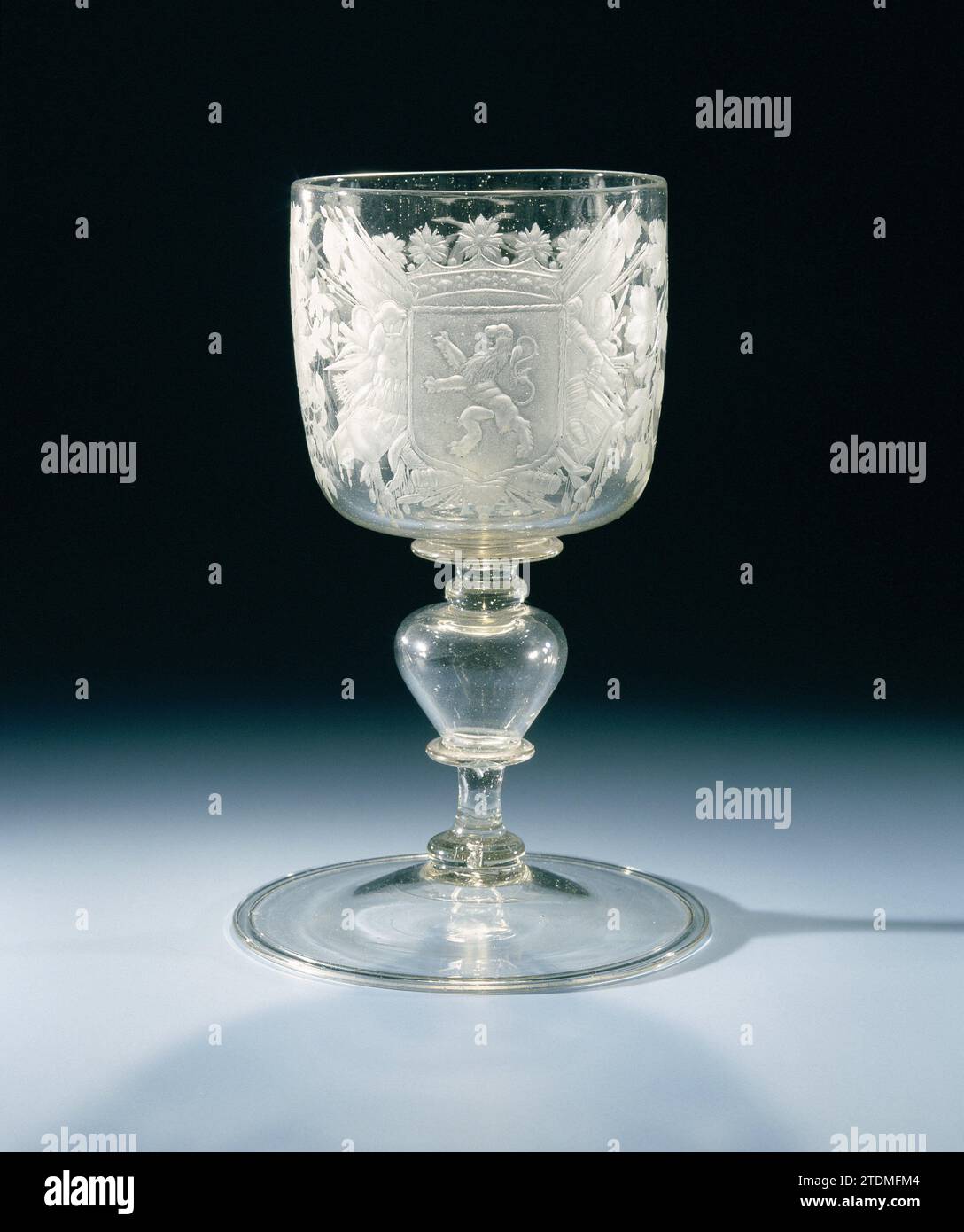 Chalip-Glas mit der Waffe von Holland, Anonym, ca. 1675 - ca. 1700 flache Basis mit umgedrehtem Fuß. Hohlbaluster Stamm mit zwei flachen Knoten und zwei Scheiben. Cylindrischer Kelch mit der Waffe Hollands, zwei Eichen, Orangenbäume und Weinreben. Glasbläser: NiederländerNördliche Niederlande Glasbläserei flacher Sockel mit umgedrehtem Boden. Hohlbaluster Stamm mit zwei flachen Knoten und zwei Scheiben. Cylindrischer Kelch mit der Waffe Hollands, zwei Eichen, Orangenbäume und Weinreben. Glasbläser: NiederländerNördliche Niederlande Glasbläserei Stockfoto