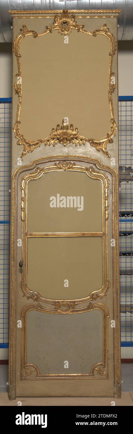 Teile einer Vertäfelung, Tür, anonym, 1740 Teile einer Vertäfelung aus grauem, goldbemalten Buchenholz. Die Tür mit Rahmen und Designer-de-porte besteht aus zwei Feldern; das obere hat geschwungene Schweller und eine Dichotomie mit Glasfenstern. Der Rahmen folgt oben an der Kontur der gewellten Oberschwellerplatte der Tür und zeigt eine gestochene Kante. Die Dessus-de-Porte mit gestochener Liste hat eine gewellte Schwelle und S-förmige Stile; die Dekoration besteht aus Rocaillem-Motiven, C-Voluten und stilisierten Palmen. SIEHE BK-NM-13223-A/D. Frankreich Holz (Pflanzenmaterial). Buche (Holz). Glasteile einer Verkleidung aus Grau W Stockfoto