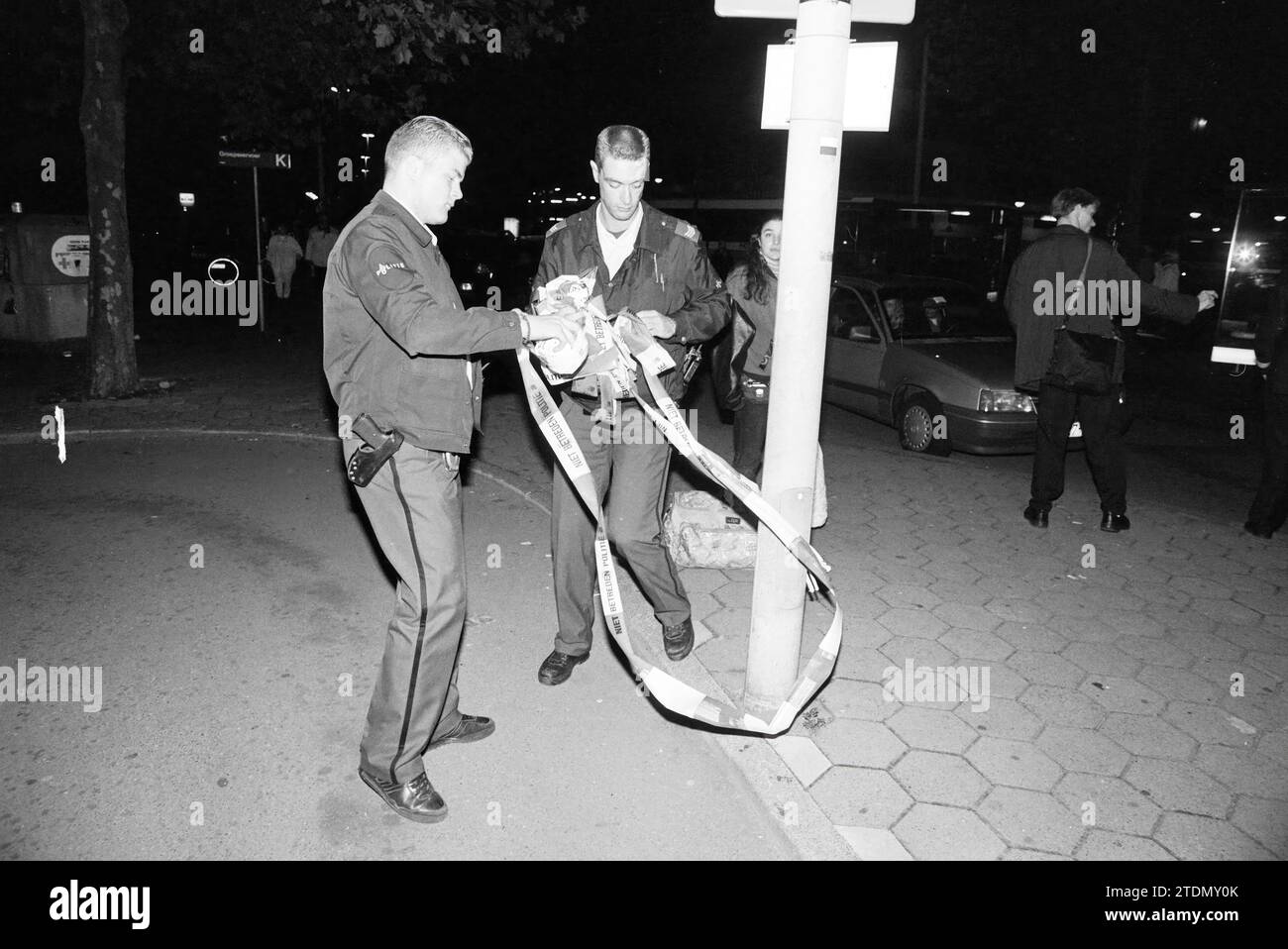 Polizeiband nach einer Katastrophe am Bahnhof Haarlem, Haarlem, Stationsplein, Niederlande, Whizgle News aus der Vergangenheit, zugeschnitten auf die Zukunft. Erkunden Sie historische Geschichten, das Image der niederländischen Agentur aus einer modernen Perspektive, die die Lücke zwischen den Ereignissen von gestern und den Erkenntnissen von morgen überbrückt. Eine zeitlose Reise, die die Geschichten prägt, die unsere Zukunft prägen Stockfoto