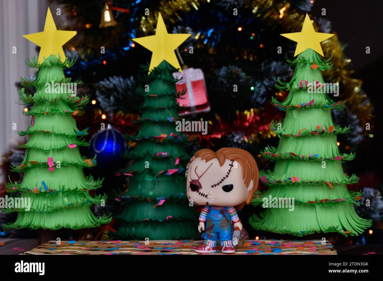 Funko Pop Actionfigur der Chucky Serienmörderpuppe aus Horrorfilmen Child's Play. Weihnachtsbäume aus handgemachtem Papier, Ornamente, Konfetti, Dekor. Stockfoto