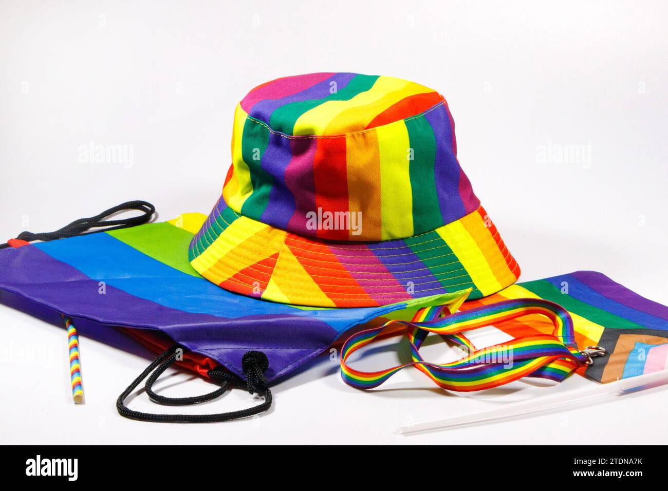 Schwuler Stolz Regenbogenhut Trageschlaufe Tasche und Flagge isoliert auf weißem Studiohintergrund Regenbogenstreifen lgbtq Stockfoto