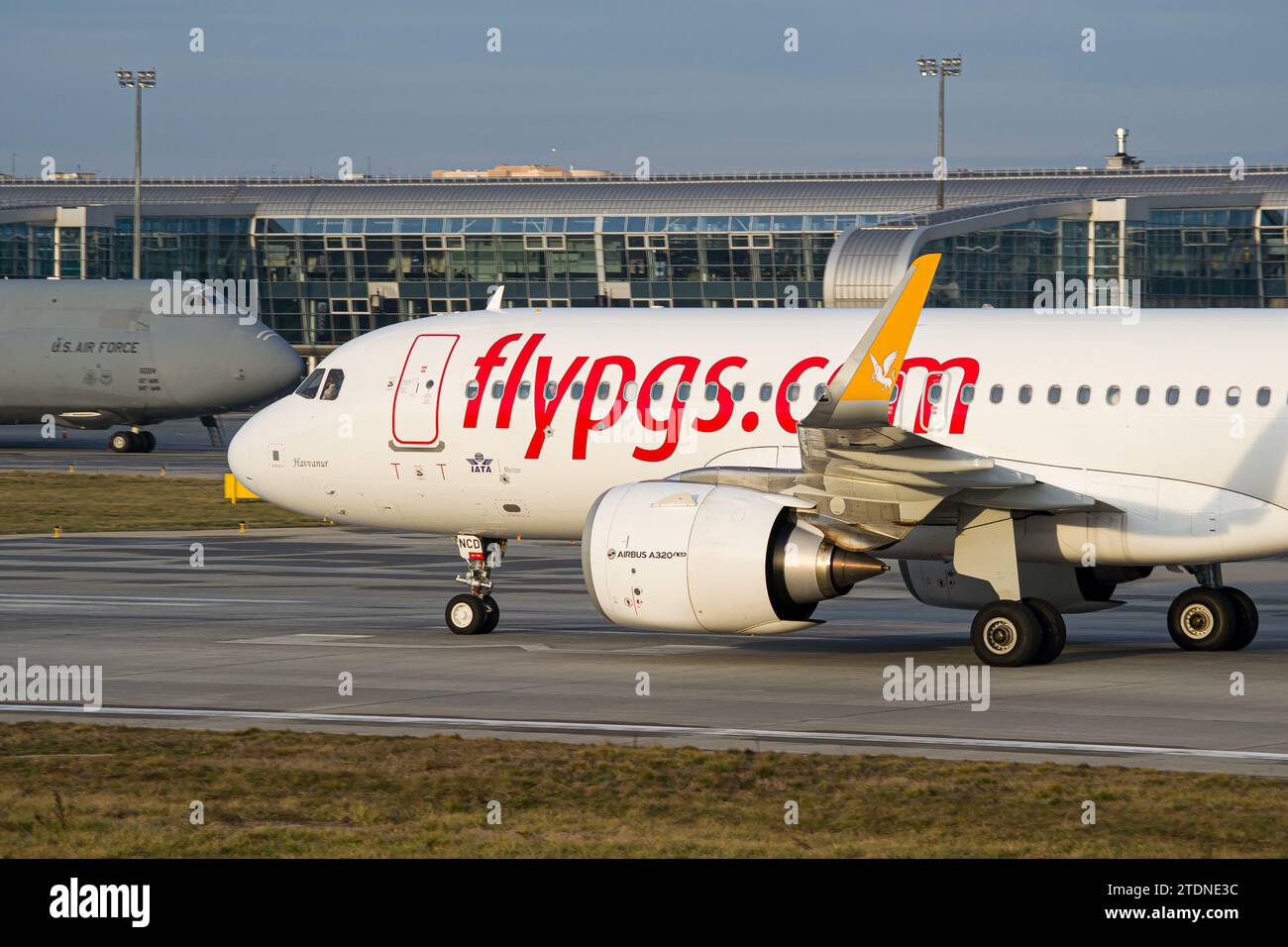 Pegasus Airlines Airbus A320 NEO Roller nach der Landung auf dem Flughafen Lemberg mit US Air Force C5 Galaxy im Hintergrund Stockfoto