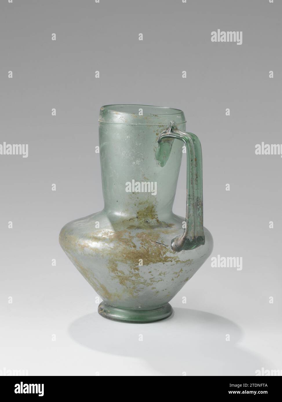 Glas, anonym (evtl.), ca. 1000 - ca. 1099 hellgrünes Glas auf einem Fußring mit einer Schicht, aber breitgefächertem Körper mit abgerundeten Schultern. Ein gerader, weiter Hals und ein gerippter, flacher Griff. Glasbläser: Iranyriëegypt Glas hellgrünes Glas auf einem Fußring mit einer Schicht, aber breitem Körper mit abgerundeten Schultern. Ein gerader, weiter Hals und ein gerippter, flacher Griff. Glasbläser: Iranyriëegypt Glas Stockfoto