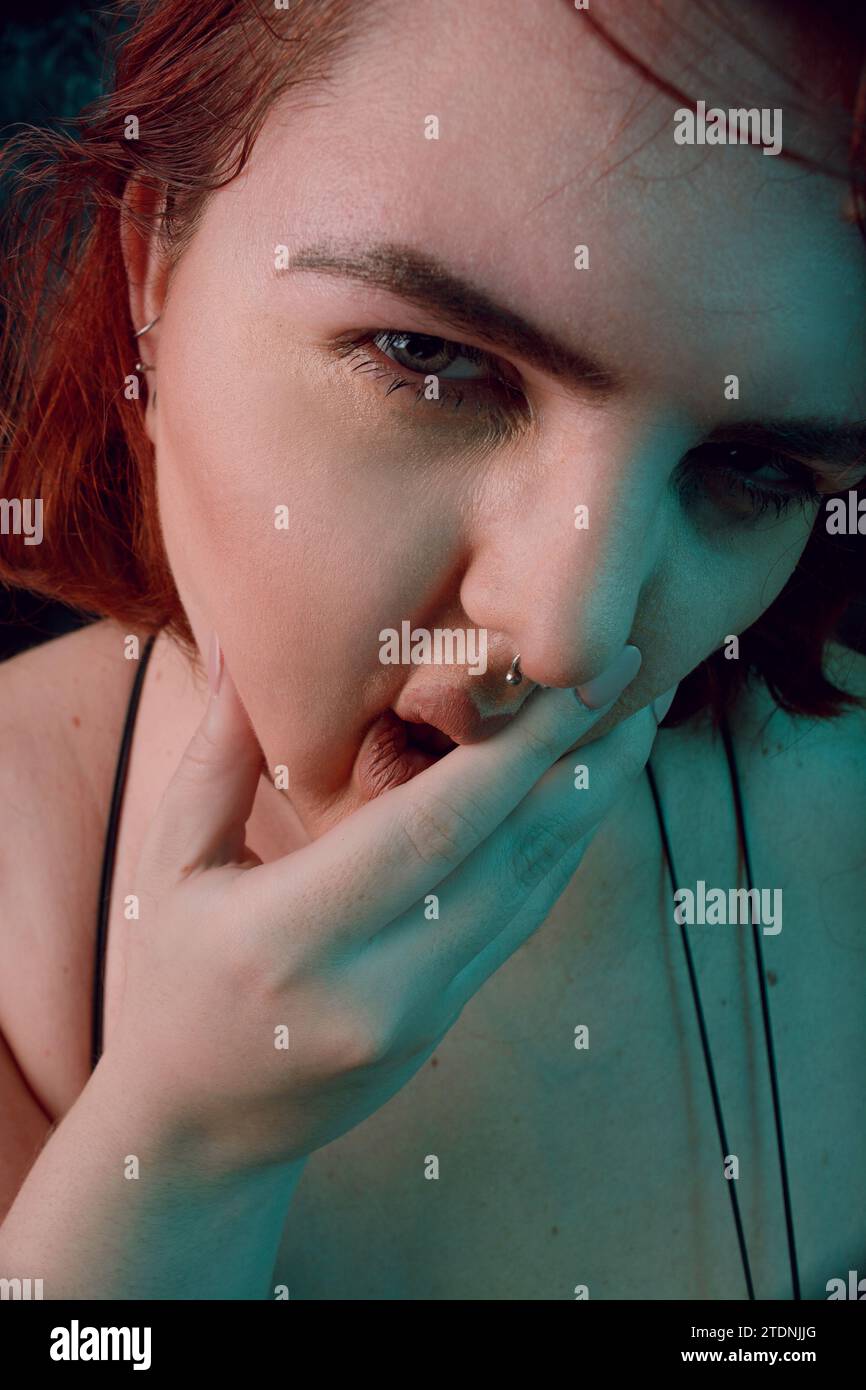 Vertikales künstlerisches Porträt für soziale Netzwerke, von großer Größe junge Latina Frau mit rotem Haar und weißem Haar, mit natürlichem Make-up, posiert sie Looki Stockfoto