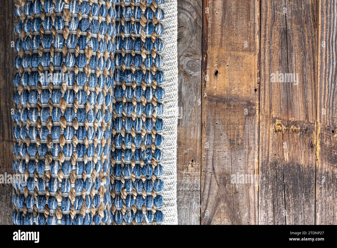 Handgewebter Teppich mit geometrischem Denim-Bereich auf Holzboden. Stockfoto
