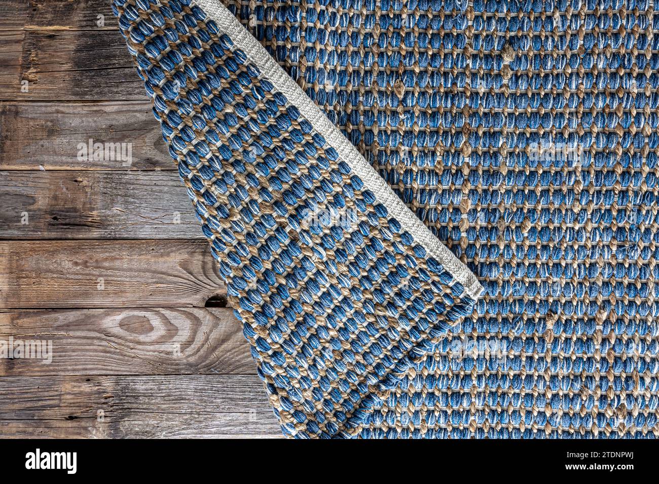 Handgewebter Teppich mit geometrischem Denim-Bereich, geflochtene Jute-Hintergrundstruktur. Stockfoto