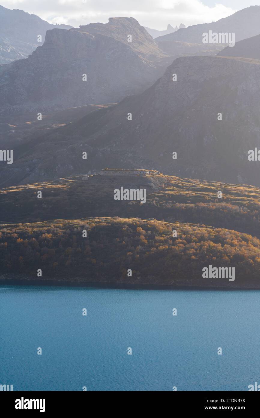 Blick auf die Berglandschaft des Mont-Cenis-Sees, Fort de Variselle (Varisello) historisches Militärgebäude, farbiger Wald im Herbst, Sonnenuntergang sanftes Licht Stockfoto