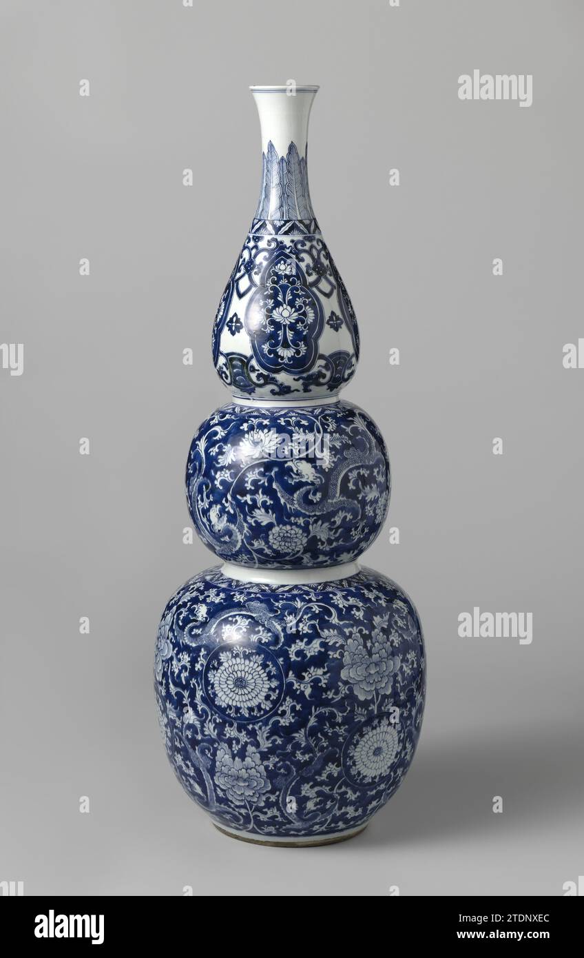 Kürbis-Vase, anonym, um 1700 - um 1720 Kalebas-Vase aus Porzellan mit drei Verdickungen, in Unterlazblau gemalt. Die beiden unteren Zwiebeln sind mit Blau bedeckt mit Blumenreben, die darin gespeichert sind (Chrysantheme, Lotus, Pioen) und Chilongs (Horoscience Dragon). Der obere Teil mit Blumenreben unterbrochen von gelappten Kartuschen mit funkelnden Lotosgetränken. Am Hals ein Band mit spitzen Blattmotiven. Auf der Unterseite mit der Joorneumnummer „N363“ in einem Doppelkreis gekennzeichnet. Blau Weiß. Porzellan. Glasur. Kobalt-(Mineral-)Malerei / Glasur Kalebas-förmige Vase aus Porzellan Stockfoto