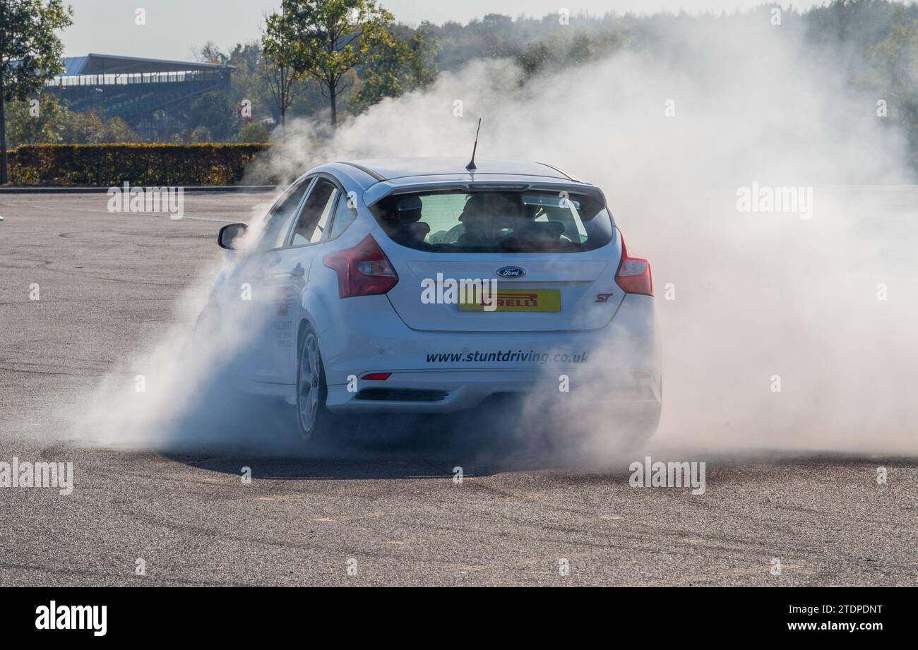 Stuntfahrer Paul Swift fährt seinen Ford Focus auf zwei Rädern und Mustang dreht sich Stockfoto