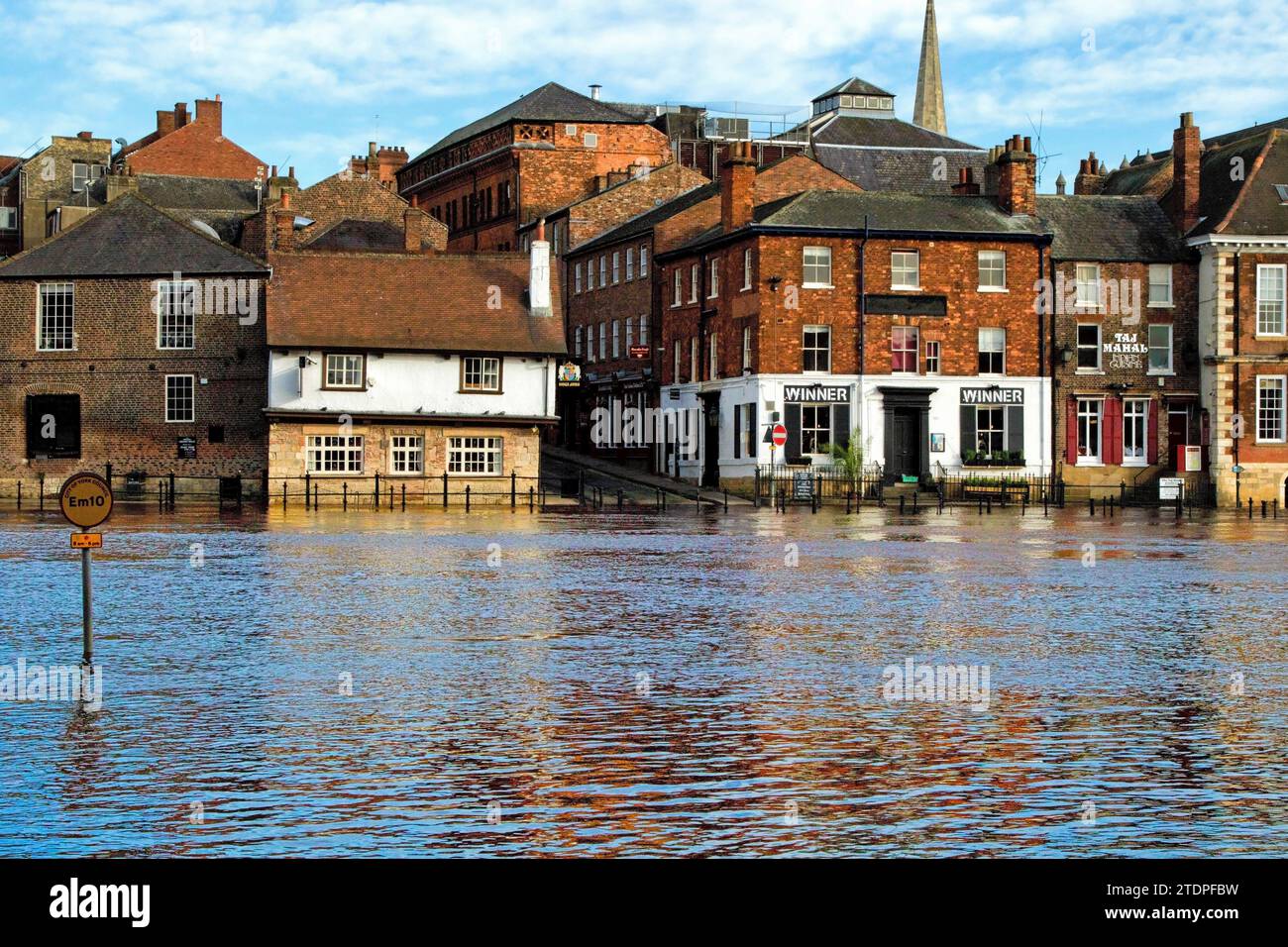 Schwere Überschwemmungen in einem städtischen Gebiet, wobei traditionelle Backsteinbauten teilweise entlang des Flusses Ouse, York, Yorkshire, Großbritannien, untergetaucht sind. Stockfoto