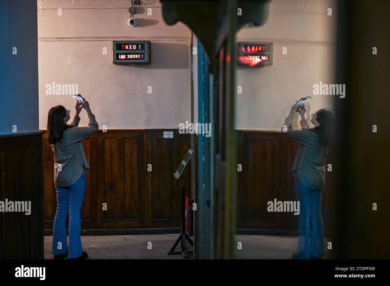 Lviv, Ukraine. Dezember 2023. Eine Frau fotografiert am 16. Dezember 2023 ein Warnschild im Haus des Schalls in Lemberg, Ukraine. Das House of Sound ist ein spezieller Raum, in dem die Mitarbeiter von Lemberg Radio mit verschiedenen Arten von Ton und Musik arbeiten. Dort finden auch Bildungsprojekte, Audioaufführungen und Tonspiele statt. KEINE VERWENDUNG RUSSLAND. KEIN NUTZEN WEISSRUSSLAND. (Foto: Ukrinform/NurPhoto)0 Credit: NurPhoto SRL/Alamy Live News Stockfoto