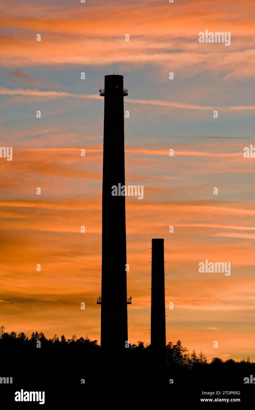 Hoher alter Schornstein im Industriegebiet und Sonnenuntergang im Hintergrund in Roznov Pod Radhostem, Tschechische republik. Stockfoto