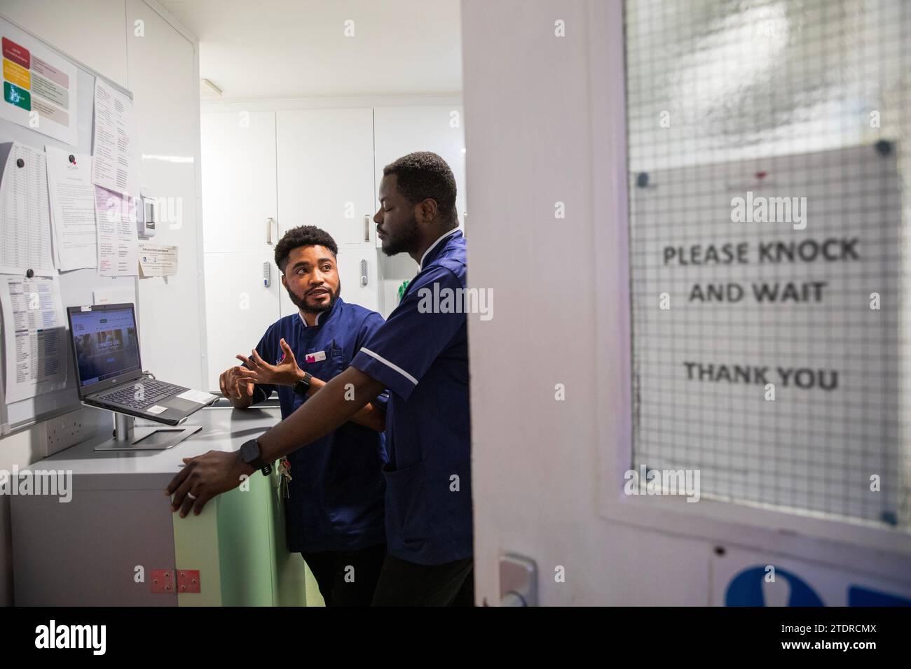 Krankenschwester Evans Sarbeng im Behandlungsraum mit Mitschwester John Haizel Cobbinah. Sowohl Evans als auch John sind Krankenschwestern aus Ghana, während Dani aus Portugal kommt. St. Cecilias Pflegeheim Scarborough. Stockfoto