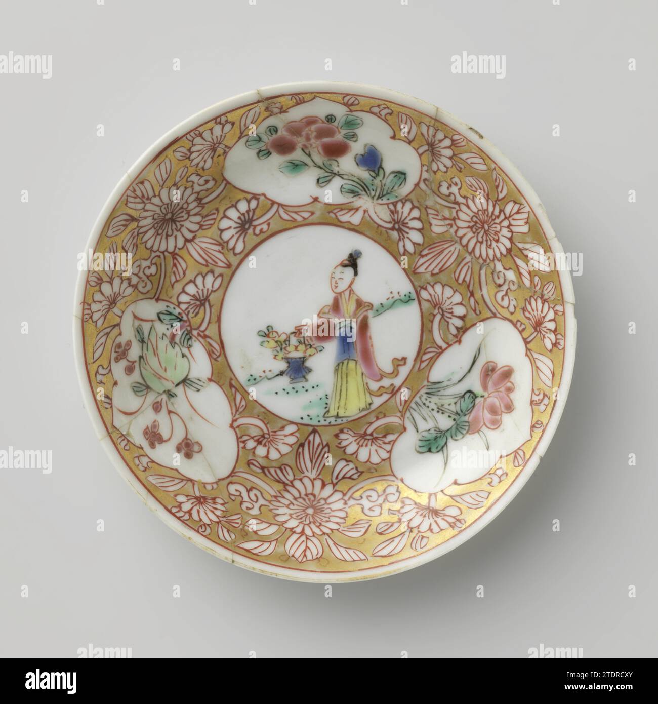 Untertasse mit einer Frau mit Blumenkorb und blühenden Pflanzen in Tafeln, anonym, ca. 1725 - ca. 1749 Porzellanschale mit ausbreitender Wand, auf der Glasur in blau, rot, rosa, grün, schwarz und Gold gemalt. Auf der Ebene des Gerichts ein Medaillon mit einer Frau in einer Landschaft mit einem Blumenkorb; für das Medaillon gerettet Blumenreben und drei Kartuschen mit blühenden Pflanzen (einschließlich Lotus) in einem goldenen Boden. Das Gericht ist kaputt. Famle Rose. Porzellan. Glasur. Gold (Metall) Malerei / Vergoldung / Glasur Porzellanschale mit ausbreitender Wand, auf der Glasur in blau, rot, rosa, grün, schwarz und lackiert Stockfoto