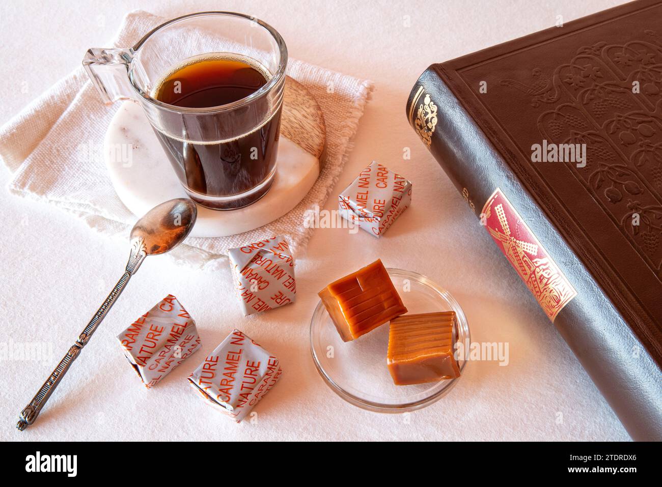 Kaffeepause mit Karamell und einem Buch, mit französischer Schrift über die Süßwaren: Karamell Natur Stockfoto