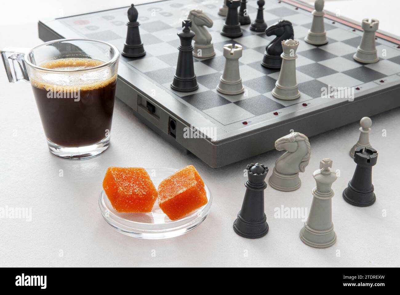 Fruchtpasten und Kaffee vor einem Schachspiel für einen Moment der Entspannung und Reflexion Stockfoto