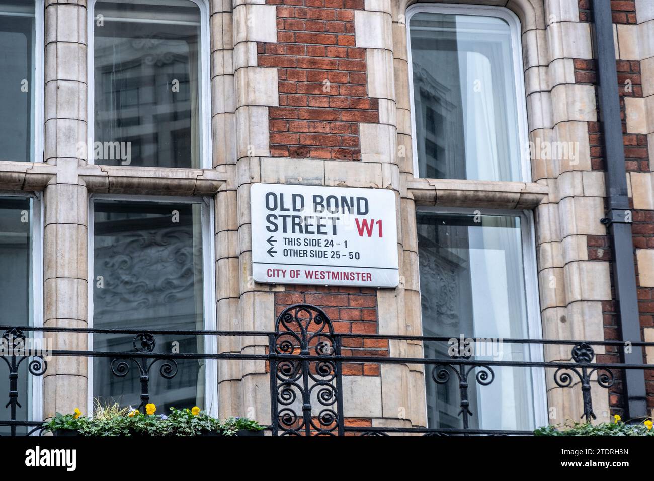 LONDON - 14. DEZEMBER 2023: Straßenschild Old Bond Street - Wahrzeichen des gehobenen Einzelhandels Stockfoto