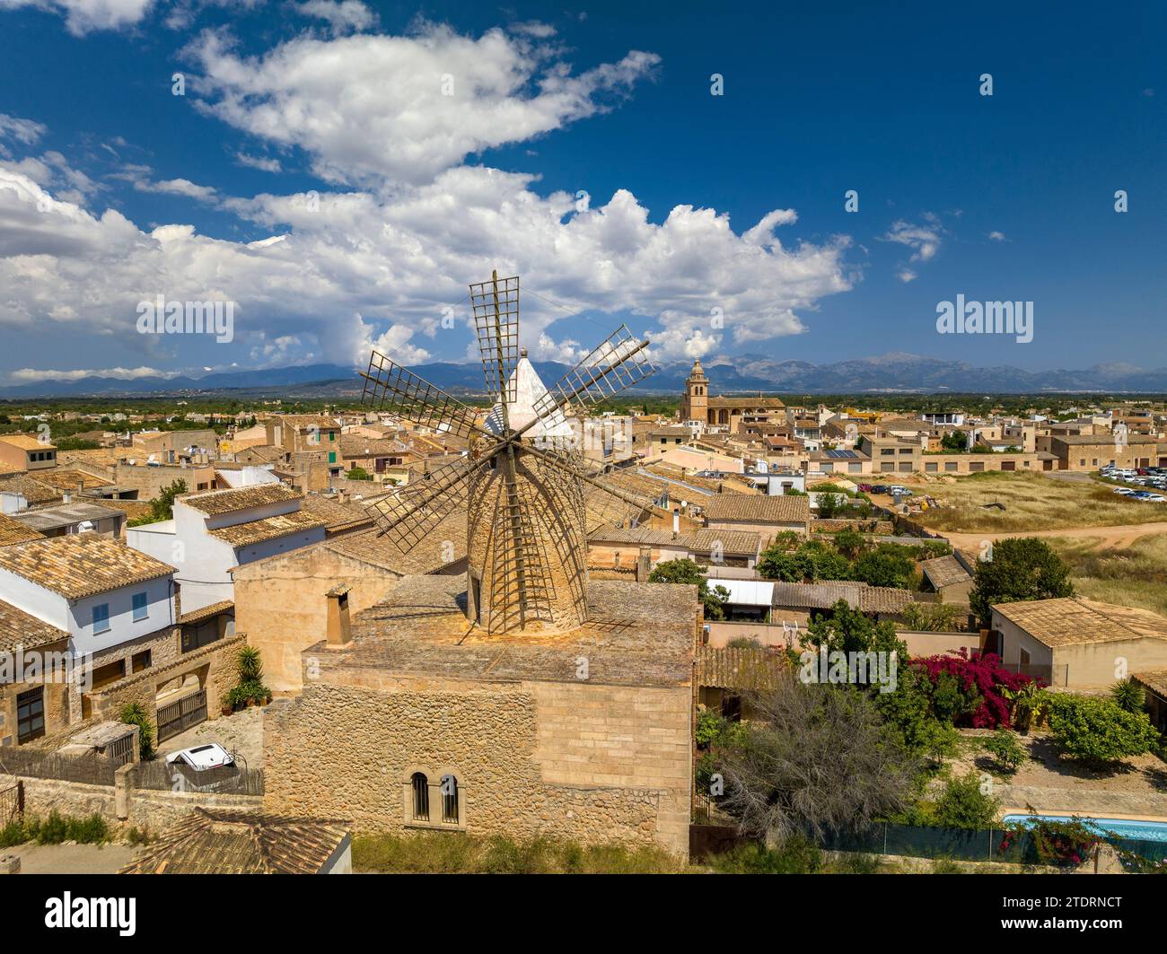 Aus der Vogelperspektive auf die Stadt Algaida und eine traditionelle Windmühle. Im Hintergrund die Serra de Tramuntana mit Wolken (Mallorca, Spanien) Stockfoto