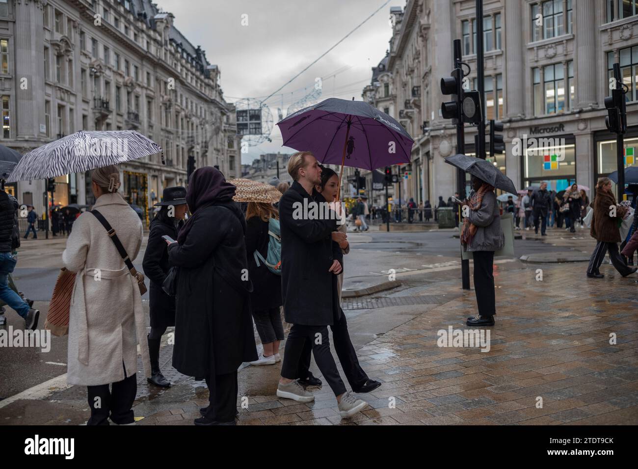 Weihnachtseinkäufer mit Regenschirmen im Oxford Circus an einem nassen Wintertag, London, England, Großbritannien Stockfoto