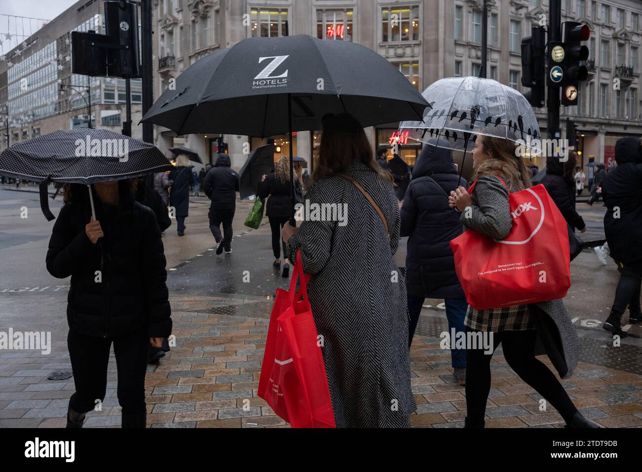 Weihnachtseinkäufer im Oxford Circus mit Regenschirmen an einem nassen Wintertag, London, England, Großbritannien Stockfoto