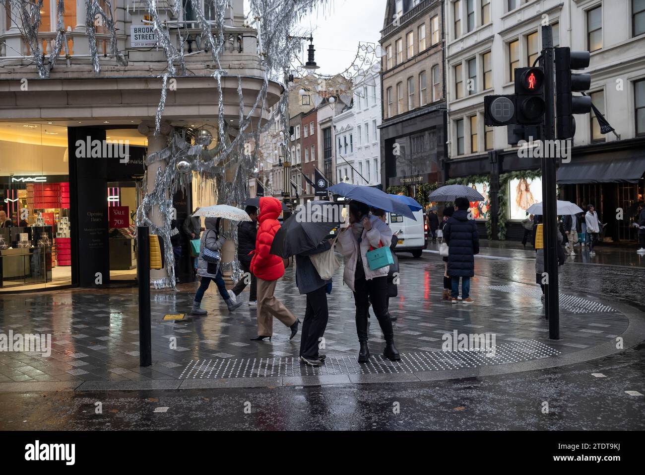 Weihnachtseinkäufer entlang der Old Bond Street an einem nassen Wintertag, London, England, Großbritannien Stockfoto
