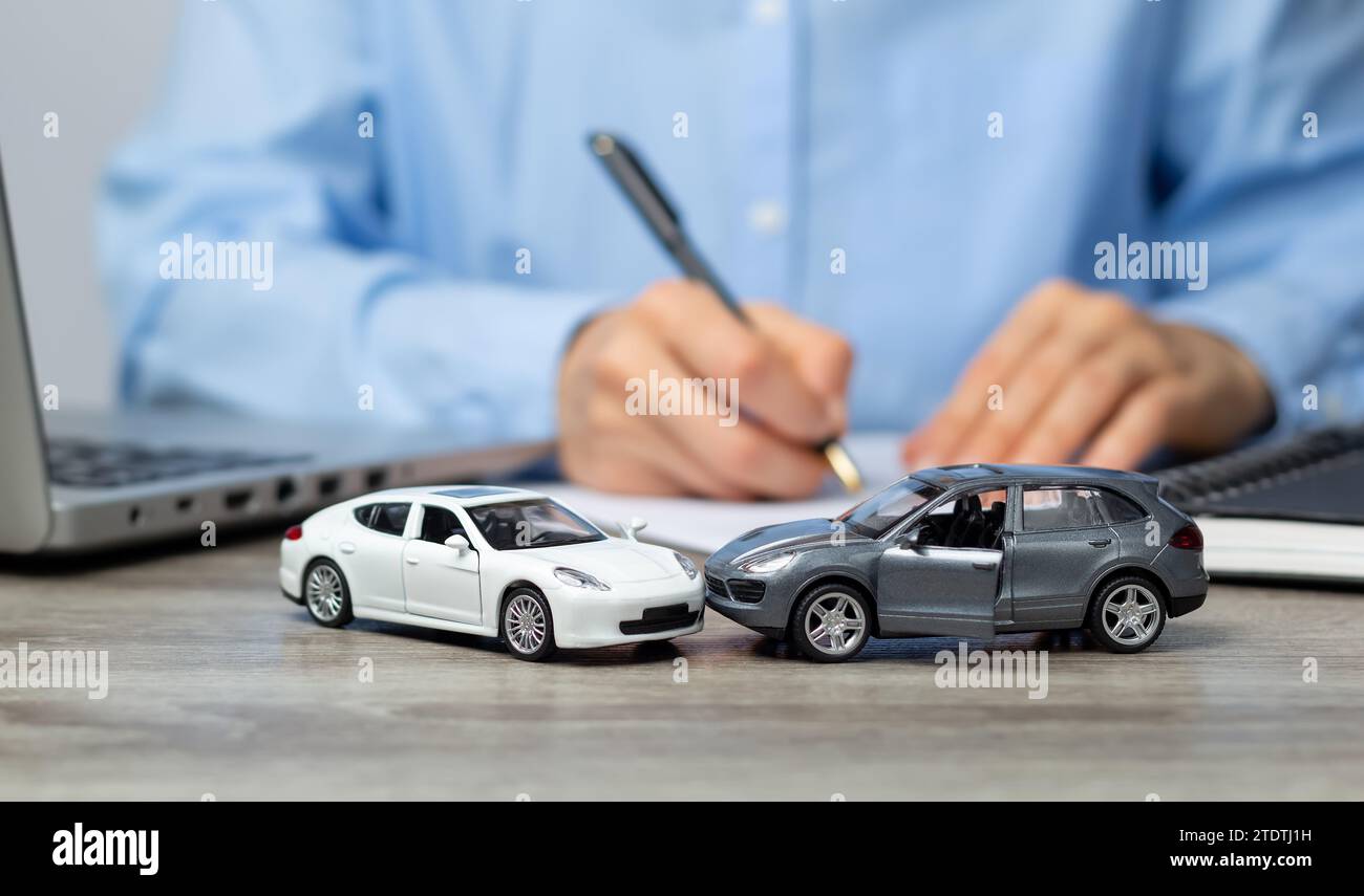 Ein Mitarbeiter einer Versicherungsgesellschaft erstellt ein Papierformular für einen Verkehrsunfall. Rechtsberatung bei einem Autounfall. Stockfoto