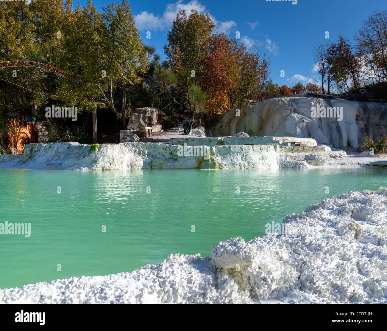 Malerische Thermalbäder mit türkisfarbenem Wasser unter Laubbäumen in Bagni San Filippo Stockfoto