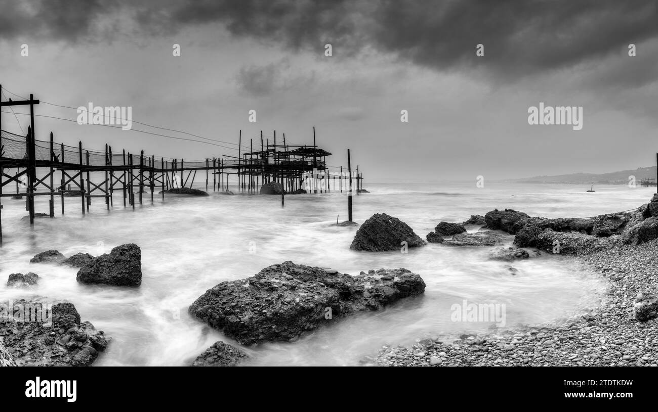 Ein Schwarzweiß-Blick auf den Trabocco Cungarelle-Haufen an einem bewölkten Regentag an der Costa dei Trabocchi in Italien Stockfoto