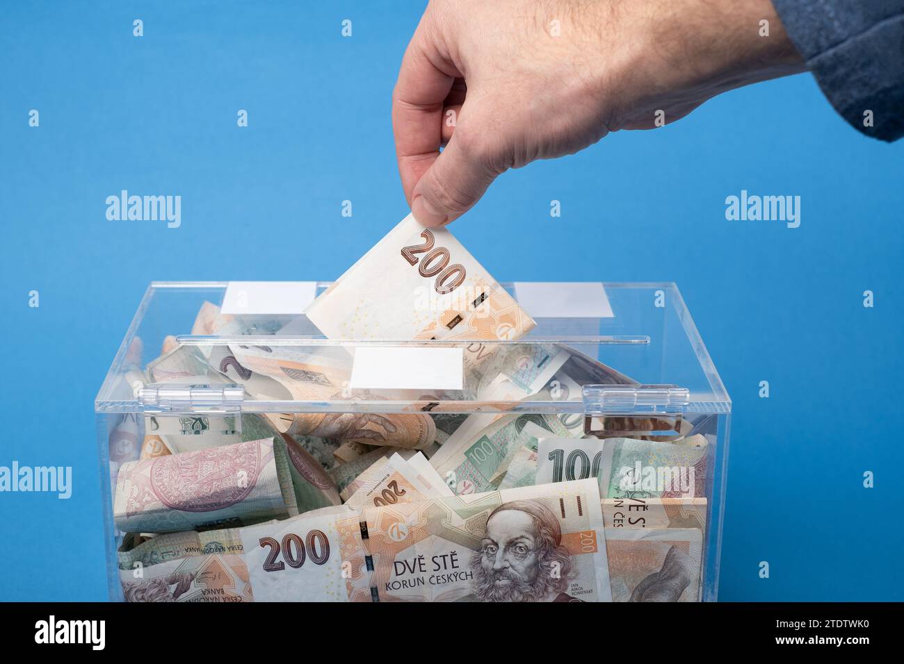 Wohltätigkeits- und Geldgeld CZK tschechische Kronen-Banknoten in eine transparente Spendenbox zur Geldspende. Eine finanzielle Unterstützung, sammelt Geld für einen edlen Zweck. Stockfoto