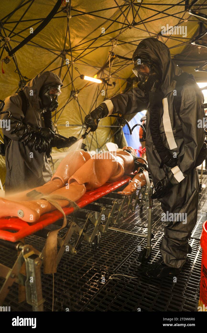 Soldaten, die dem 83. Chemikalienbataillon zugewiesen sind, dekontaminieren einen simulierten Unfall während eines Massendekontaminierungsszenarios in Fort Stewart, Georgia, 8. Dezember 2023. Während der Übung testete die Task Force 3 des Bataillons die Soldaten mit Massendekontamination, komplexen technischen Such- und Extraktionsszenarien sowie Aufklärungs- und Überwachungsszenarien. (Foto der US-Armee von SPC. Duke Edwards) Stockfoto