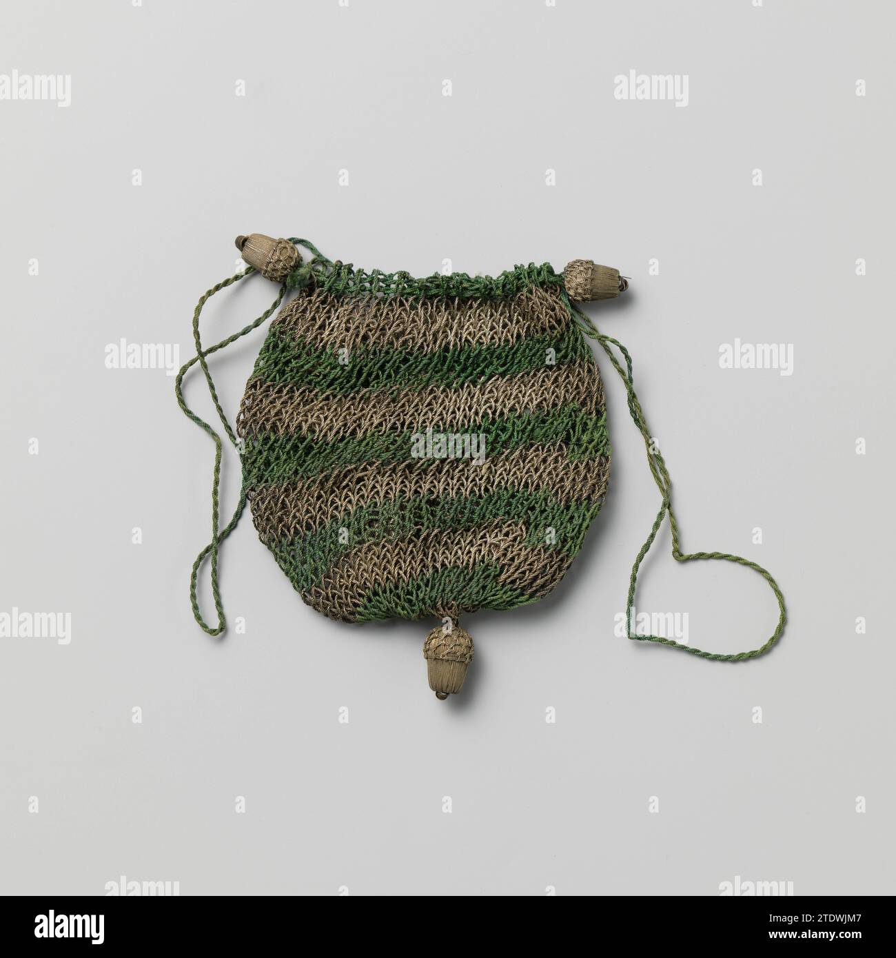 Börse aus dunkelgrüner Seide, durchsetzt von horizontalen Bahnen aus Silberfäden, mit einer Wickelschnur, auf der zwei Eicheln aus Silberdraht, anonym, um 1700 - um 1750 Fair in Form einer Kugel aus dunkelgrüner Seide, durchsetzt mit horizontalen Bahnen aus Silberdraht. Zwei Eicheln Silberdraht sind am verdrehten grünen Schlosskabel befestigt. Auf dem abgerundeten Boden der Messe befindet sich auch eine Eichel aus silbernem Garn. Niederlande (möglicherweise) ganz: Seide. Ganz: Silbergewinde. Acorn: Holz (pflanzliches Material). Ruck: Silbergewinde. Schnur: Seidenhäkelmesse in Form einer Krokakugel Stockfoto