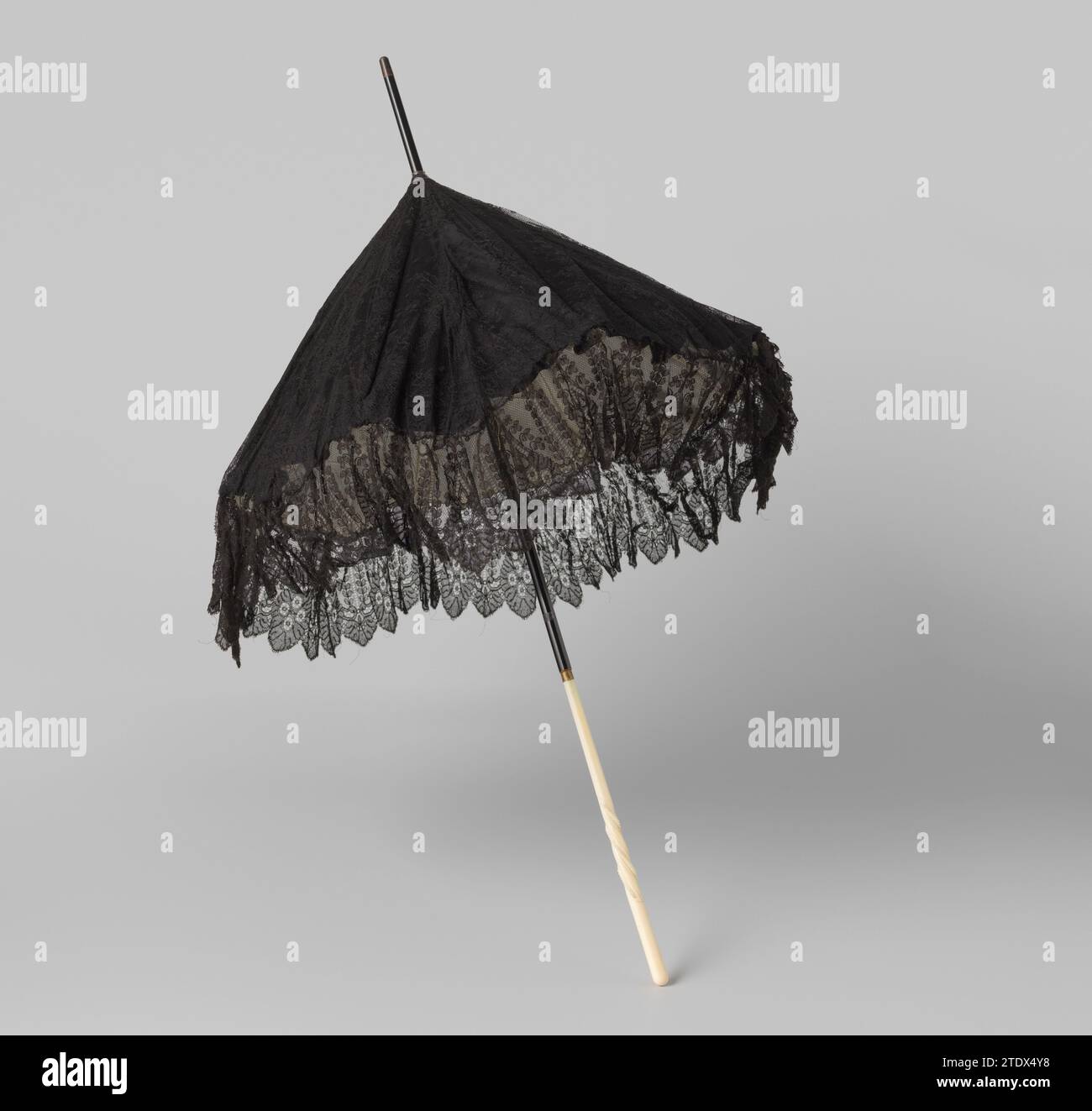 Sonnenschirm mit Deck aus mechanischer chantilly-Spitze, verziert mit Blumen und Blättern, auf schwarzem Satin und mit weißer Pongé-Seite auf einem Holzstab mit Griff aus geschnittenem Elfenbein, anonym, um 1880 Sonnenschirm mit Deck aus mechanischer chantilly-Spitze, verziert mit Blumen und Blättern, auf schwarzem Satin und mit weißer Pongé-Seite ausgekleidet auf einem Holzstock mit Griff aus Relief elfenbeinfarben geschnitten. Parasoldek mit einem Strauß in jeder Schale, bestehend aus zwei großen Blumen und vier langen Blättern. Rand der Ovale mit Blattdekoration über 'Gadronen' mit drei Blättern. Um einen Hängeband mit hängender Feder, gehen Sie Stockfoto