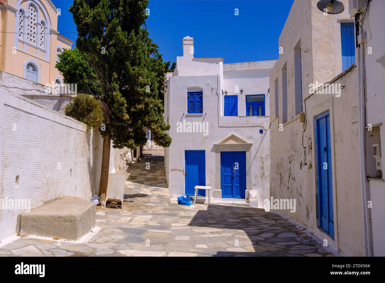 Pyrgos, GR - 6. August 2023: Straße in einem traditionellen griechischen Dorf mit weiß getünchten weißen und blauen Häusern Stockfoto