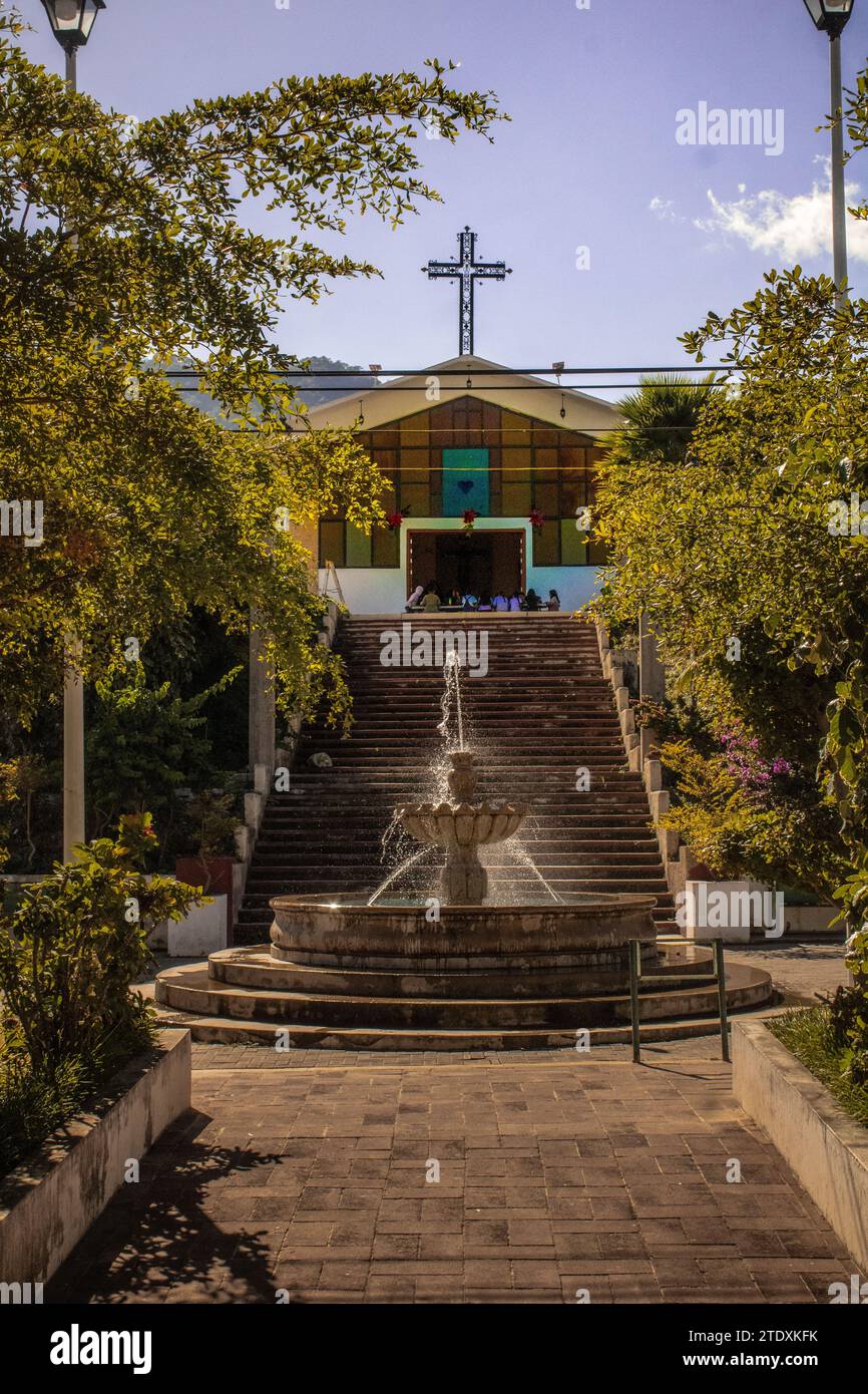 Tropische Ruhe trifft auf moderne Spiritualität: Eine malerische moderne Kirche schmückt ein kleines mexikanisches Dorf in Nayarit, umgeben von üppigem tropischem Grün Stockfoto